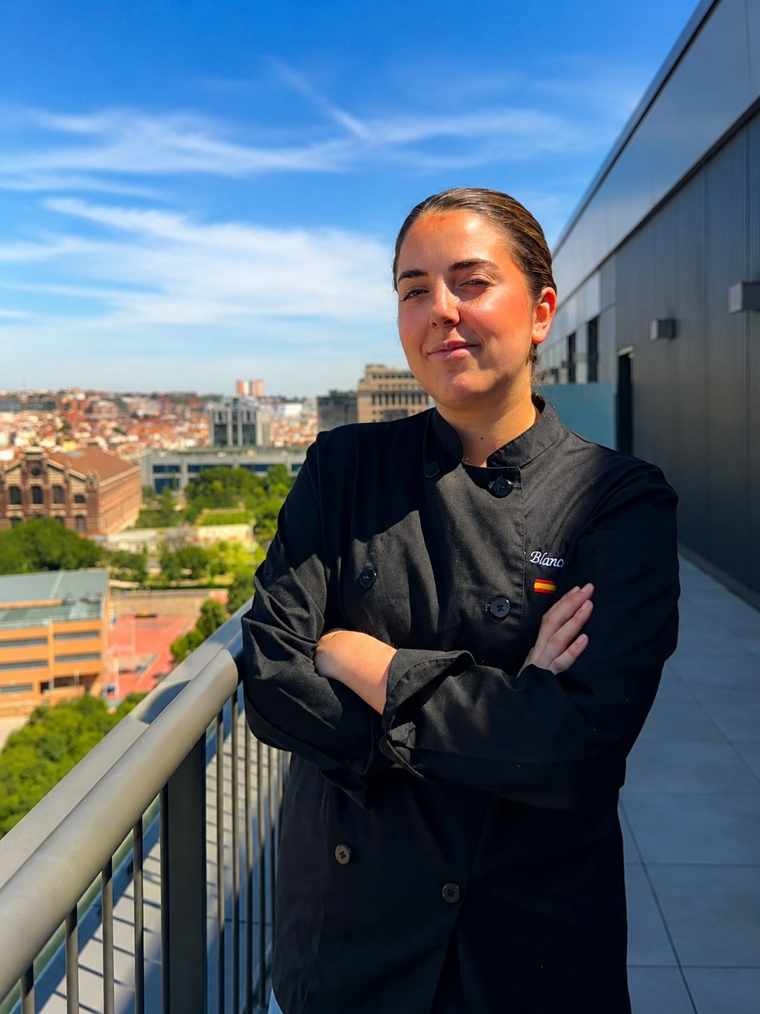 Blanca Juan Serrato, chef y fundadora de Sucar Catering, en una terraza con el skyline de Madrid de fondo
