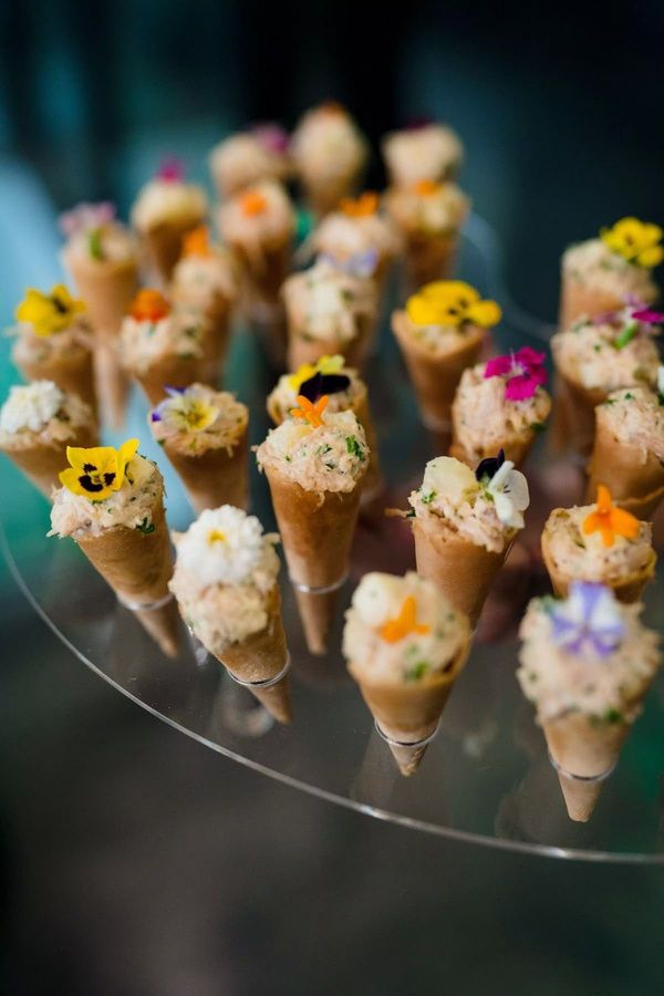 Conos crujientes con relleno de temporada y flores comestibles — uno de los bocados firma de Sucar Catering