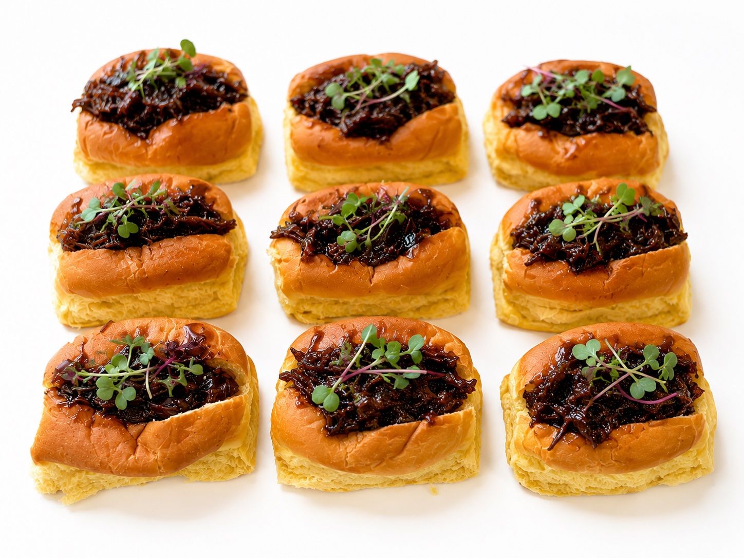 Brioches, vista de bandeja — La bandeja tal cual sale de cocina: nueve brioches iguales, brotes recién puestos y todo a su sitio.