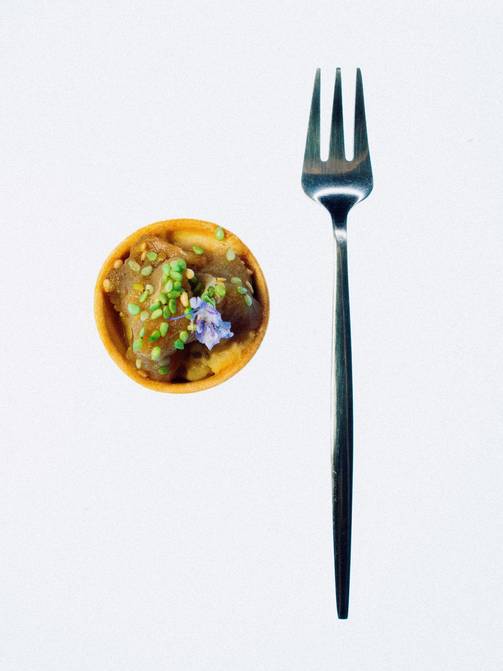 Tartaleta de guiso y flor comestible — Guiso lento sobre masa crujiente, sésamo y flor comestible.