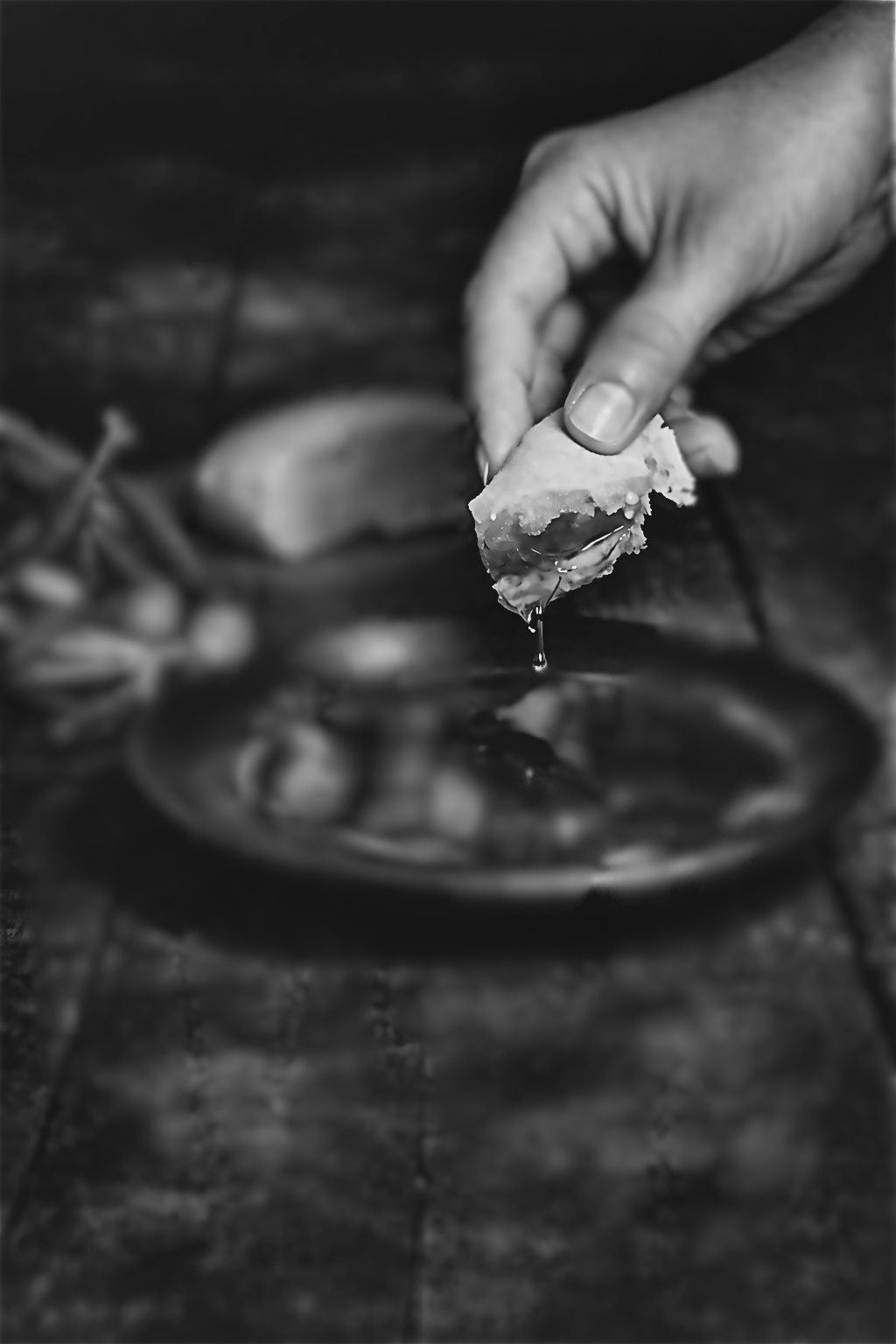 Mano mojando un trozo de pan en la salsa de un plato — el gesto que da nombre a Sucar Catering