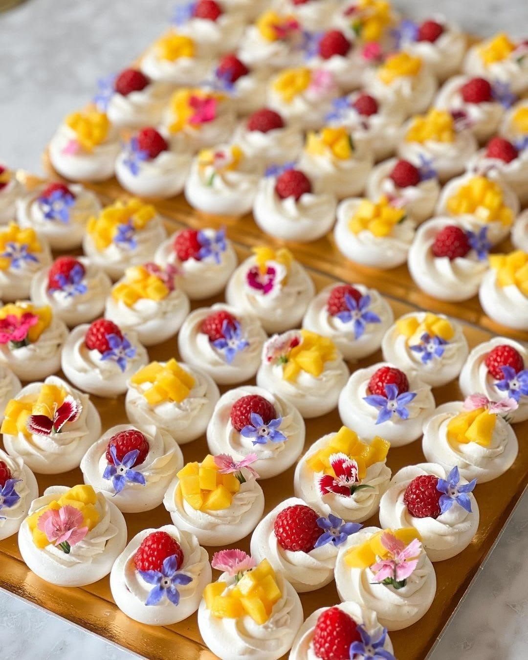 Pavlova de fruta tropical — Merengue · maracuyá · mango · flores comestibles